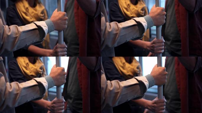 公共巴士上通勤者手握杆的特写镜头
