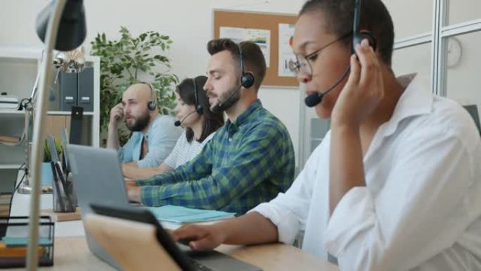 呼叫中心的工作人员与客户聊天，并在室内的办公桌上使用计算机打字