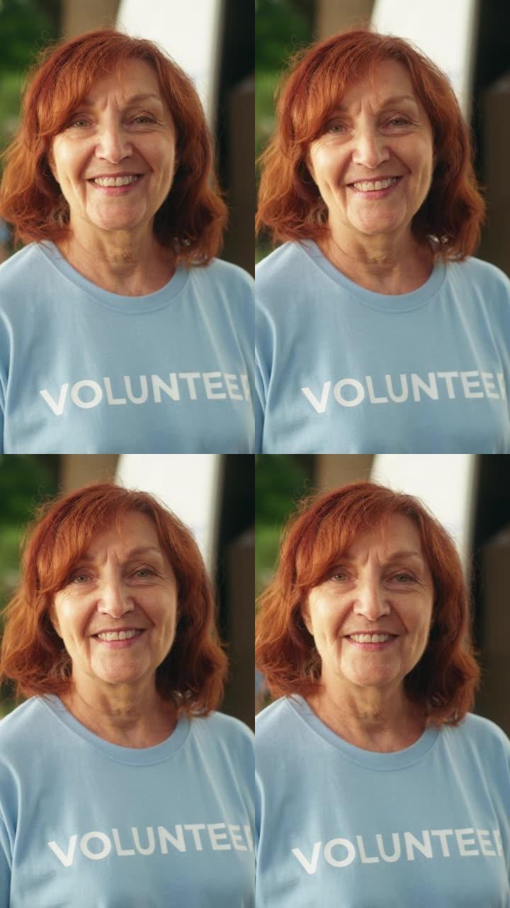 一位快乐乐于助人的中年女性志愿者的垂直肖像。成年白人妇女穿着蓝色t恤，微笑着看着相机。人道主义援助、