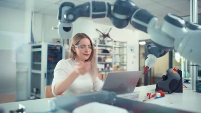 自动化女工程师在笔记本电脑上打字，并在工厂移动仿生爪。现代设备与计算机科学产业概念的新时代