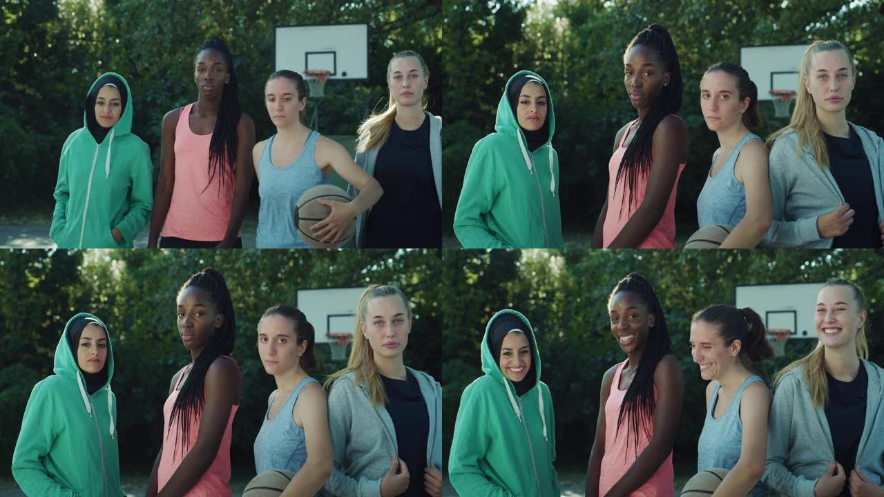 一群女少年在室外篮球场的肖像照。多种族的女孩认真地走向相机，然后一起大笑。玩友谊赛的朋友们玩得开心