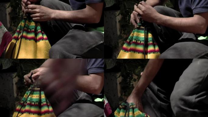 一个男人合上他的安第斯拉绳背包。特写。