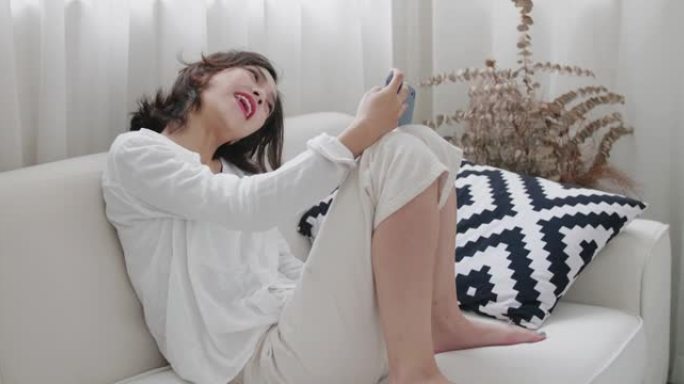女人打视频电话休闲舒适女子睡衣蜷缩在沙发