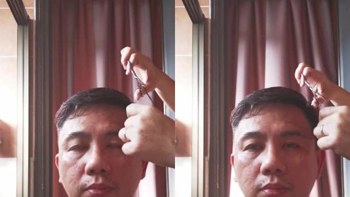 亚洲中国中年男子在家由妻子理发
