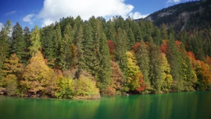 在阳光明媚的秋日，空中拍摄了风景秀丽的全景，在山上有树的湖上。