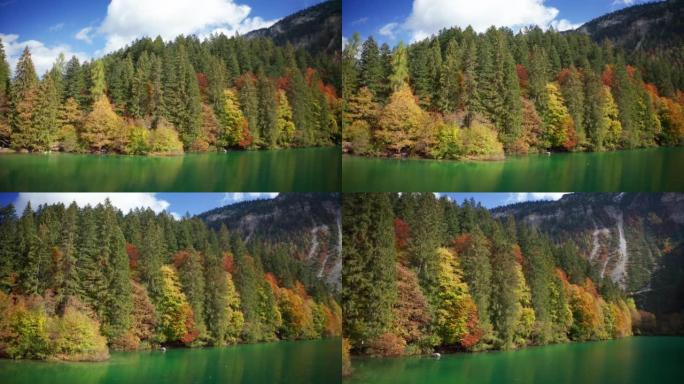 在阳光明媚的秋日，空中拍摄了风景秀丽的全景，在山上有树的湖上。