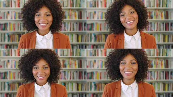 书架前一个自信的女商人的肖像。美丽时尚的非洲女企业家或律师，脸上带着友好的微笑，在图书馆里看起来很自