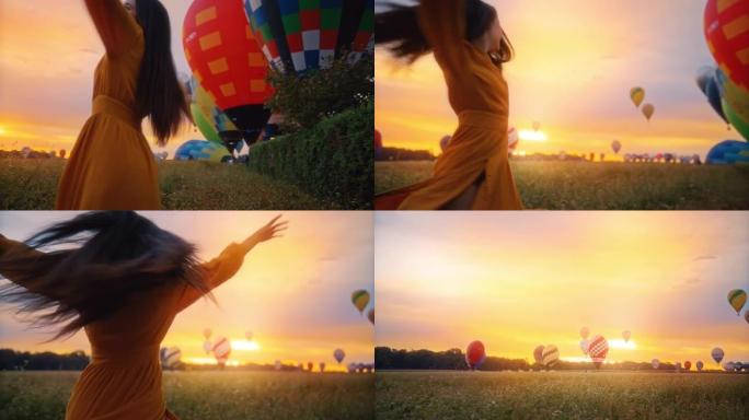 无忧无虑的年轻女子带着热气球在田园诗般的田园诗中旋转