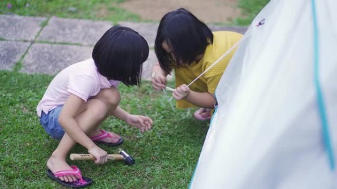 亚洲华人家庭在他们的房屋后院建立帐篷露营周末活动