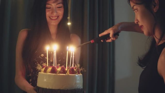 快乐的亚洲朋友在家用蛋糕庆祝生日。