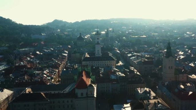 无人机拍摄乌克兰利沃夫和平的夏季日出，旧市政厅塔楼建筑和屋顶城市景观。