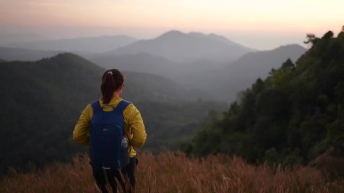 女旅行者徒步上山庆祝成功