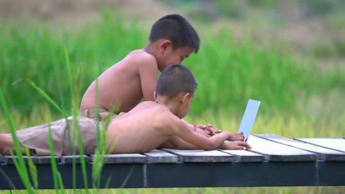两个农村男孩玩笔记本开心