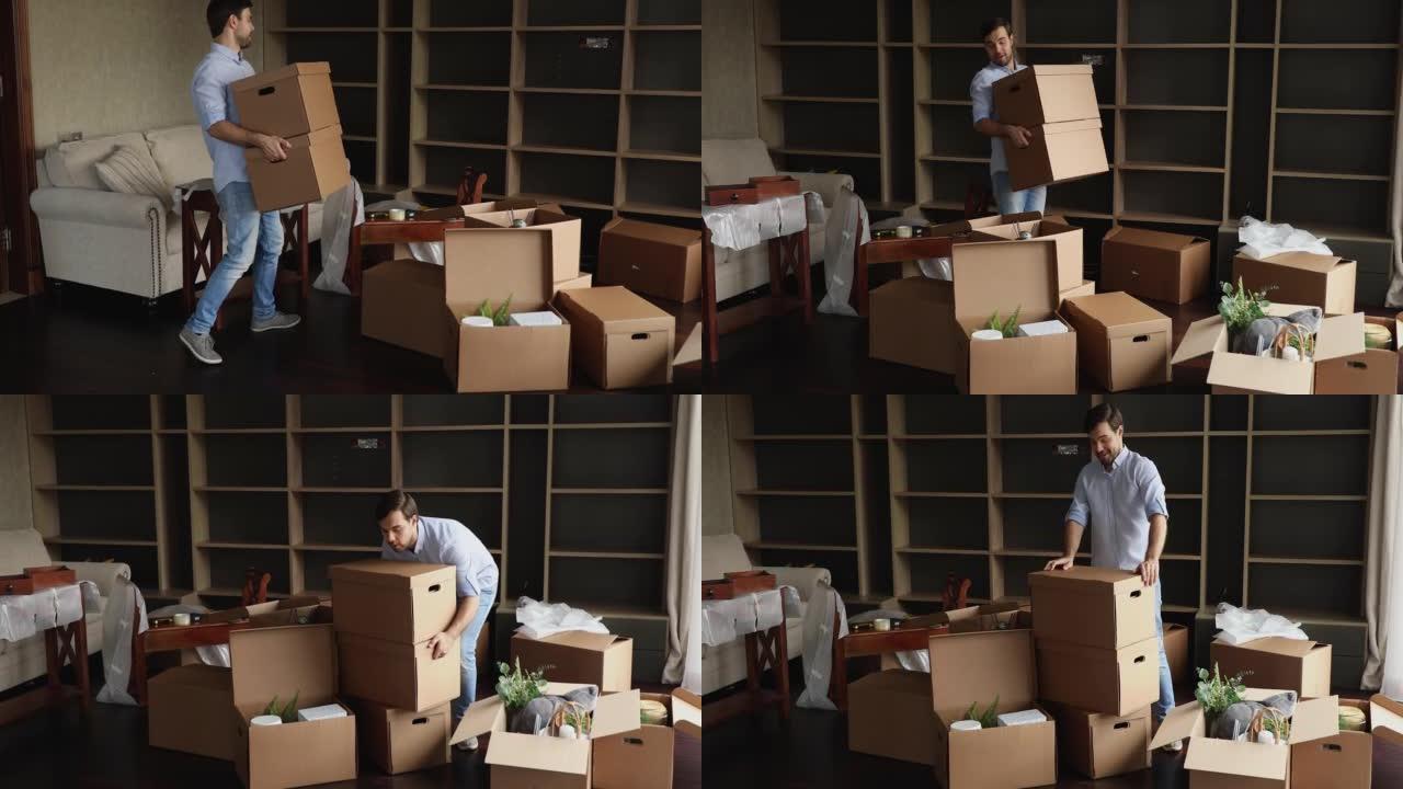 男子将装有个人物品的盒子带到未装修的客厅