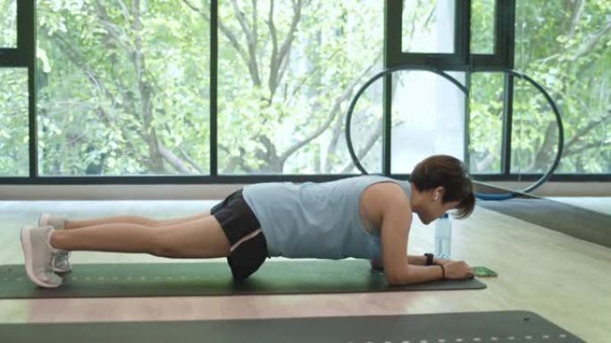 亚洲妇女在在线运动训练中使用智能手机，多莉射击