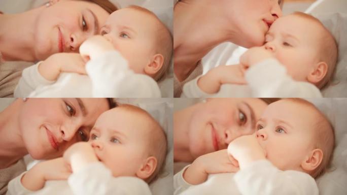 有爱心的母亲躺在卧室里，一个可爱的新生婴儿。妈妈和一个蹒跚学步的孩子在一起，在额头上亲吻婴儿。童年、