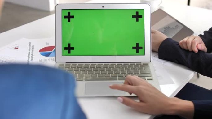 两名商务人士使用笔记本电脑绿屏