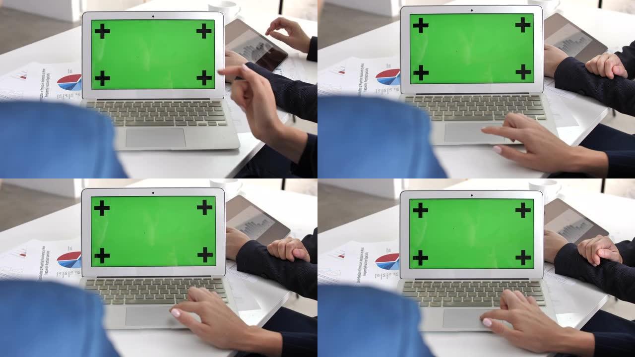 两名商务人士使用笔记本电脑绿屏