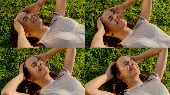 超级SLO MO年轻女子躺在草地上喜欢喷水