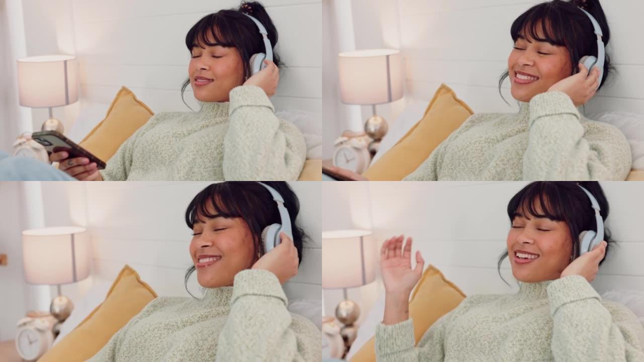 电话、音乐和放松，一个女人躺在家里卧室的床上，用耳机播放音频。自由、健康和精神卫生与年轻女性放松与电