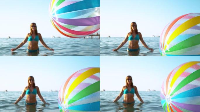 特写: 穿着比基尼的开朗女人观察充气球掉入海中