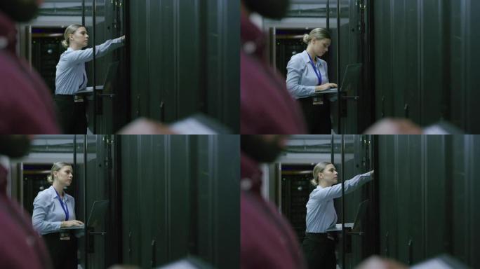 4k视频片段，一名年轻女子在服务器室工作时使用笔记本电脑