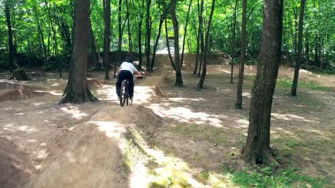 骑自行车的人正骑着障碍物穿越森林