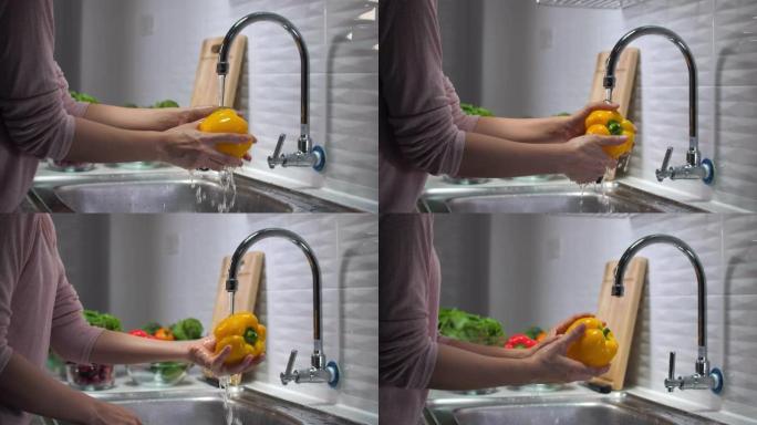 女人的手在家里洗甜椒