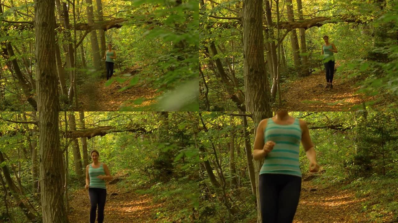 特写: 健康的女人在风景秀丽的森林里徒步旅行时，沿着一条空旷的小路慢跑。