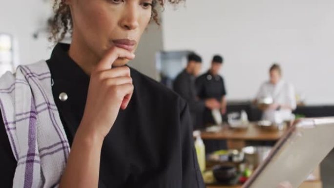 混合种族女厨师使用数字平板电脑