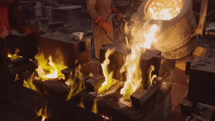 工厂工人在铸钢铸造厂将熔融金属倒入铸件的特写视图