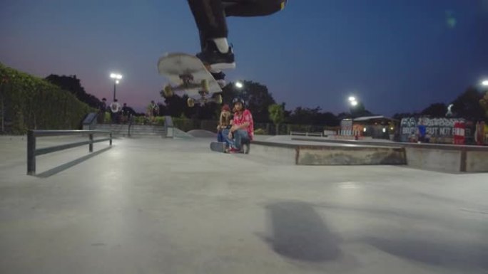 亚洲朋友一起在公园玩滑板。