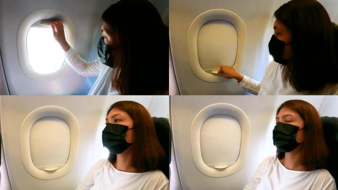 戴面罩的女乘客关闭飞机窗户休息