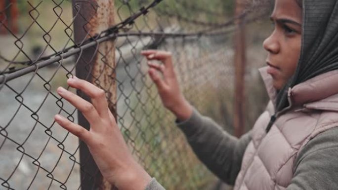 铁丝网围栏上的难民女孩