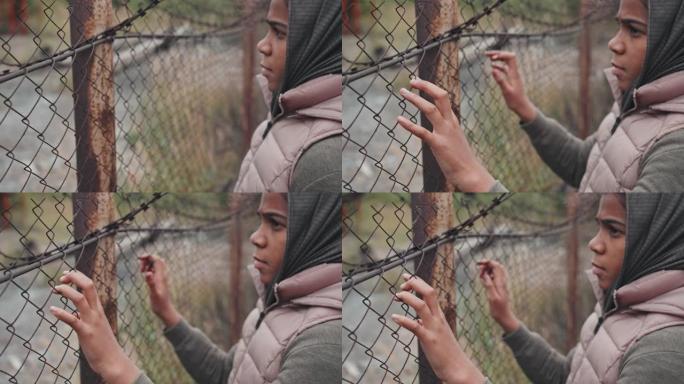 铁丝网围栏上的难民女孩