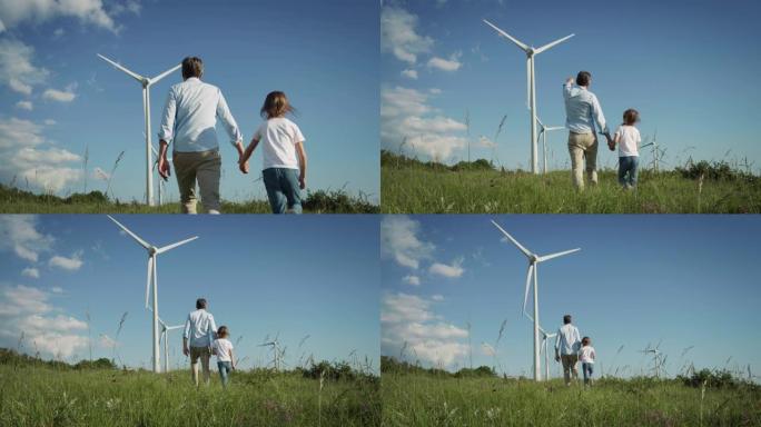 父亲和小女儿手拉手走在风电场中的背景。他们参观了一片绿地，并指向风力涡轮机。可持续的可再生能源确保我