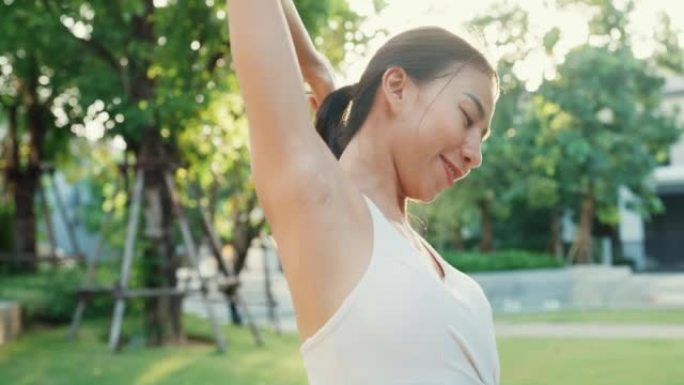 美丽的年轻亚洲运动员女士在日落时分在城市公园环境中跑步后锻炼身体热身。