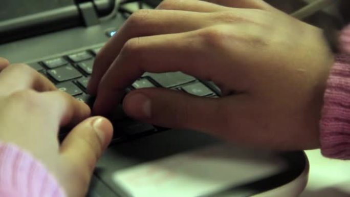 一名视力障碍的女高中生的手在课堂上的电脑课上触摸电脑键盘。特写。