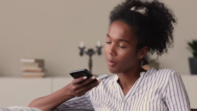 手持智能手机的混血女人通过免提电话与朋友交谈