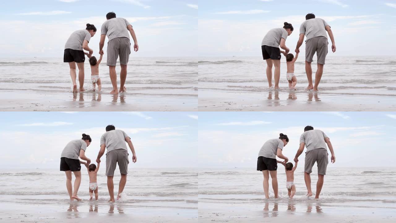 快乐的亚洲父亲，母亲和宝贝儿子在沙滩上学习日落大海的乐趣。假期
