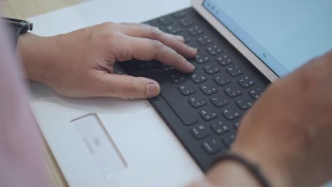 女人的手打字数字平板电脑的键盘，特写