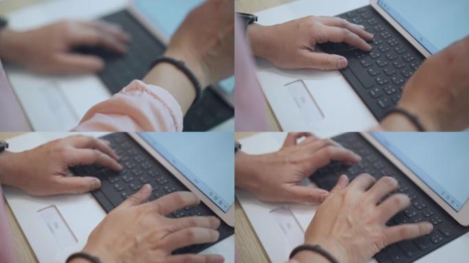 女人的手打字数字平板电脑的键盘，特写