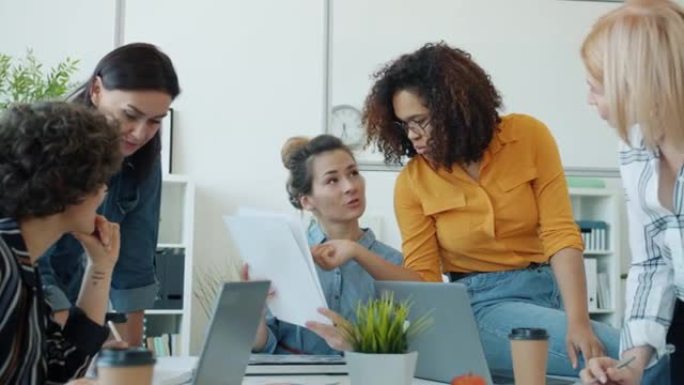 聪明的女性上班族在工作中与笔记本电脑交谈和工作的慢动作分享想法