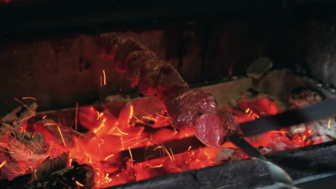 棍子上的肉正在煤上烤