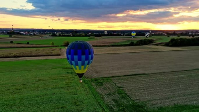 日落时分，热气球在乡村的乡村上空飞行