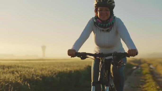 中年妇女在土路上骑自行车的肖像