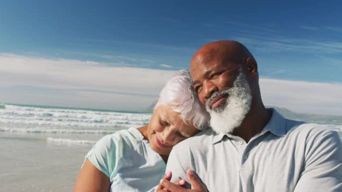 微笑的资深非洲裔美国夫妇在海滩上拥抱