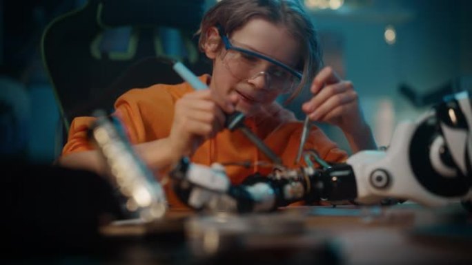 聪明的年轻十几岁的小学生正在他的科学爱好机器人项目中学习电子产品，焊接线和电路板。孩子正在他房间里研