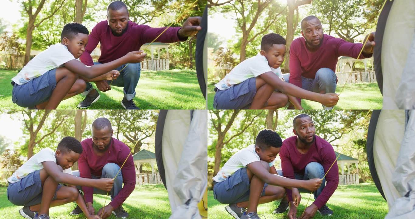 非裔美国人爸爸和儿子在花园里一起搭帐篷