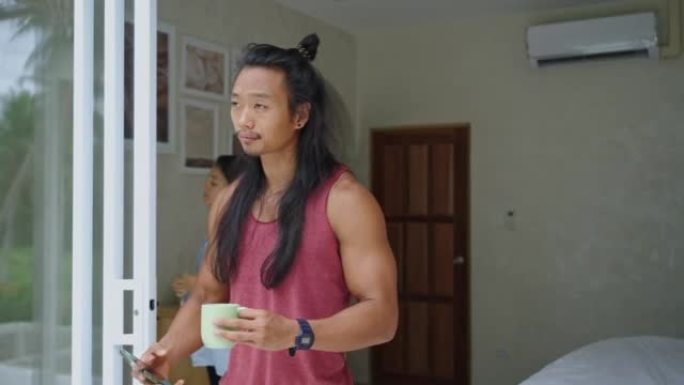 亚洲男子用咖啡和电话度过一个早晨